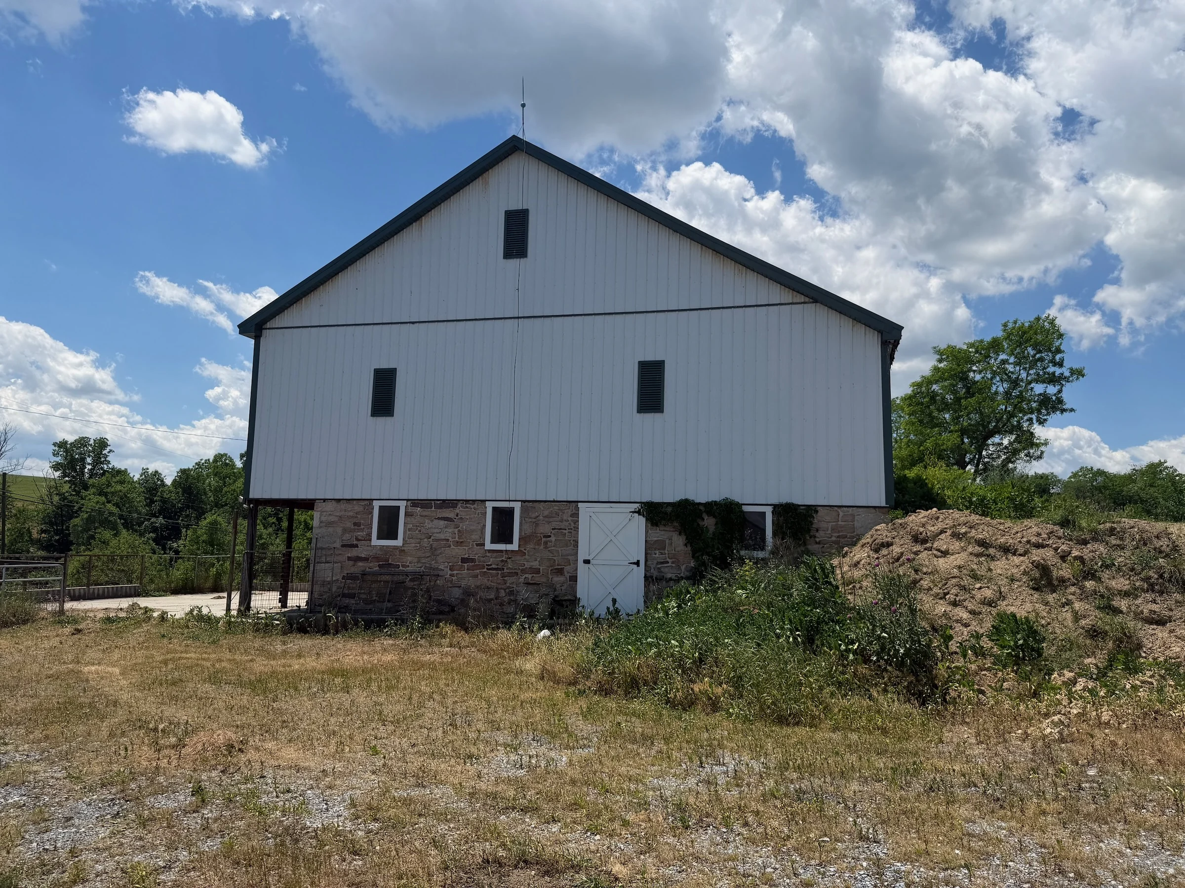 The white barn above its stone lower level